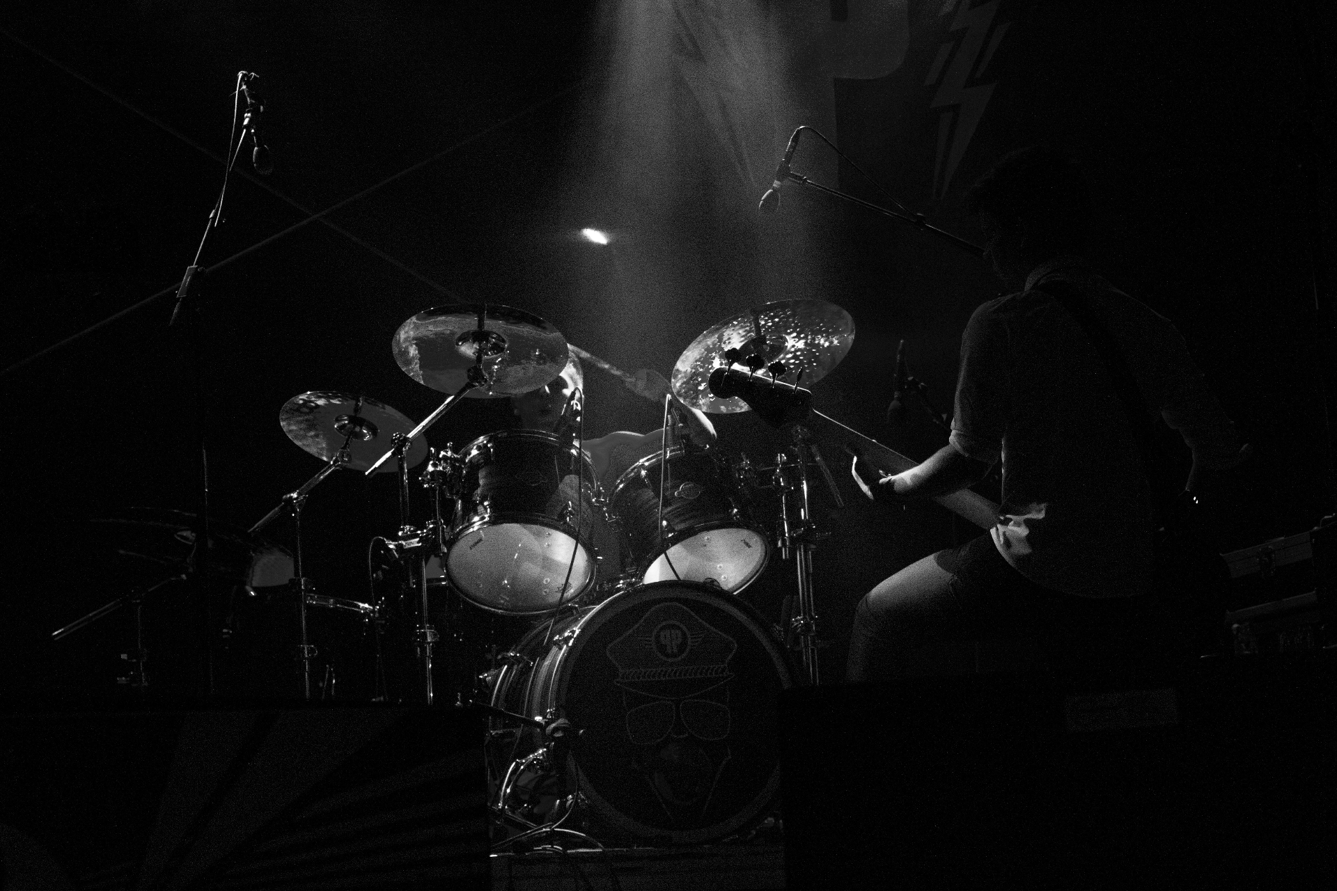 Drum kit on stage under dramatic spotlight at a rock concert